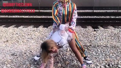 Clown pounds dame on train tracks